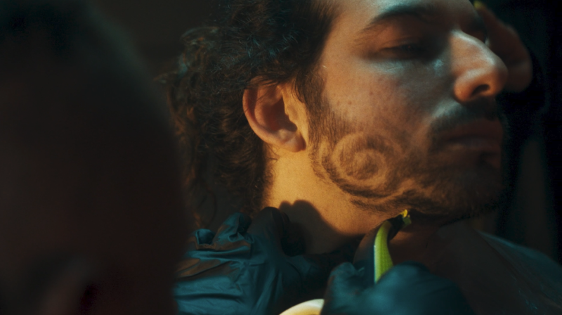 It shows a man's jaw with his beard having been shaved into with swirls