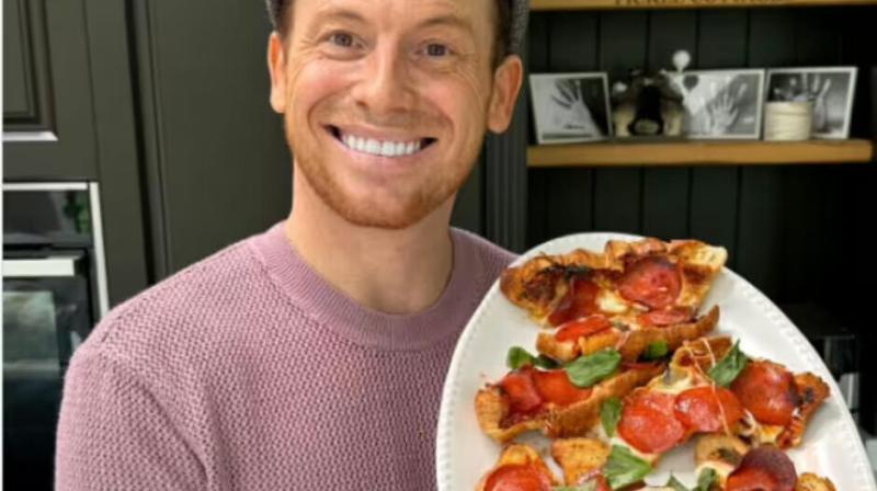 Joe Swash holding a plate of food