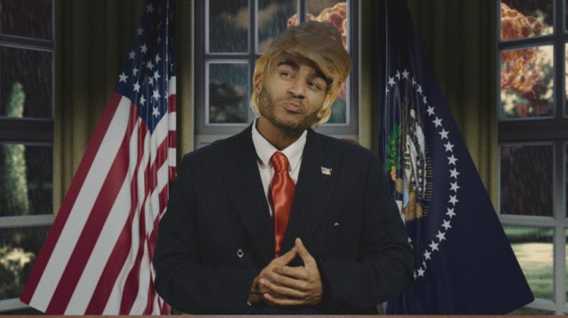 Munya Chawawa dressed in a Donald Trump wig and suit in How To Survive a Dictator: North Korea