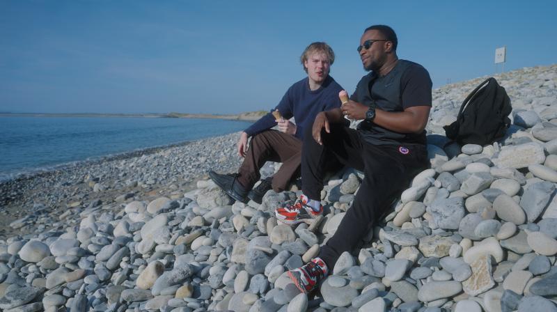 Babatunde Aleshe and Finlay Christie on a pebble beach on the island of Ireland.