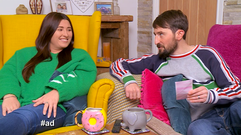 Gogglebox stars Sophie and Pete smiling over a lottery ticket