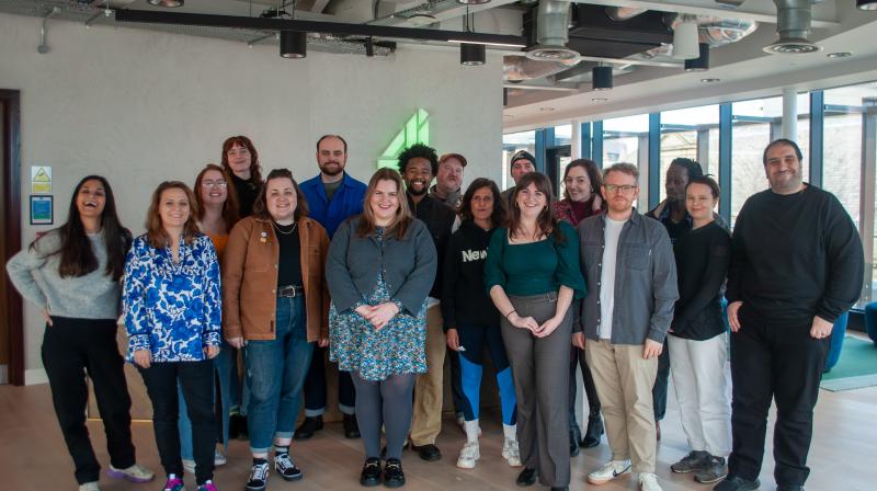 It shows 17 people smiling at the camera