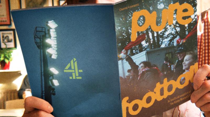 It shows a young woman holding a fanzine that on the front in orange text says Pure Football over the top of fans heading to a football match. On the black is a black cover with the Channel 4 logo