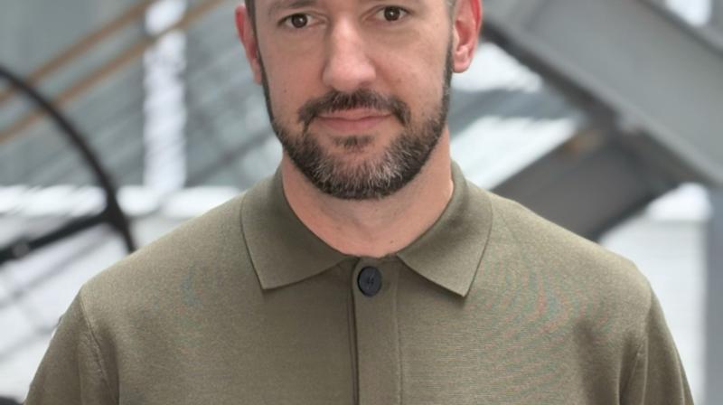 Adam wearing a green shirt facing the camera.