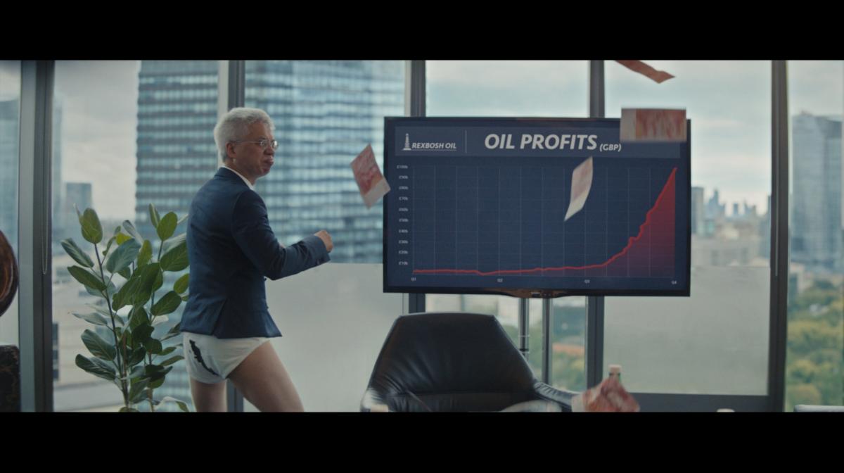 Image shows a man dancing in his underpants in front of a presentation indicating huge increases in oil profits