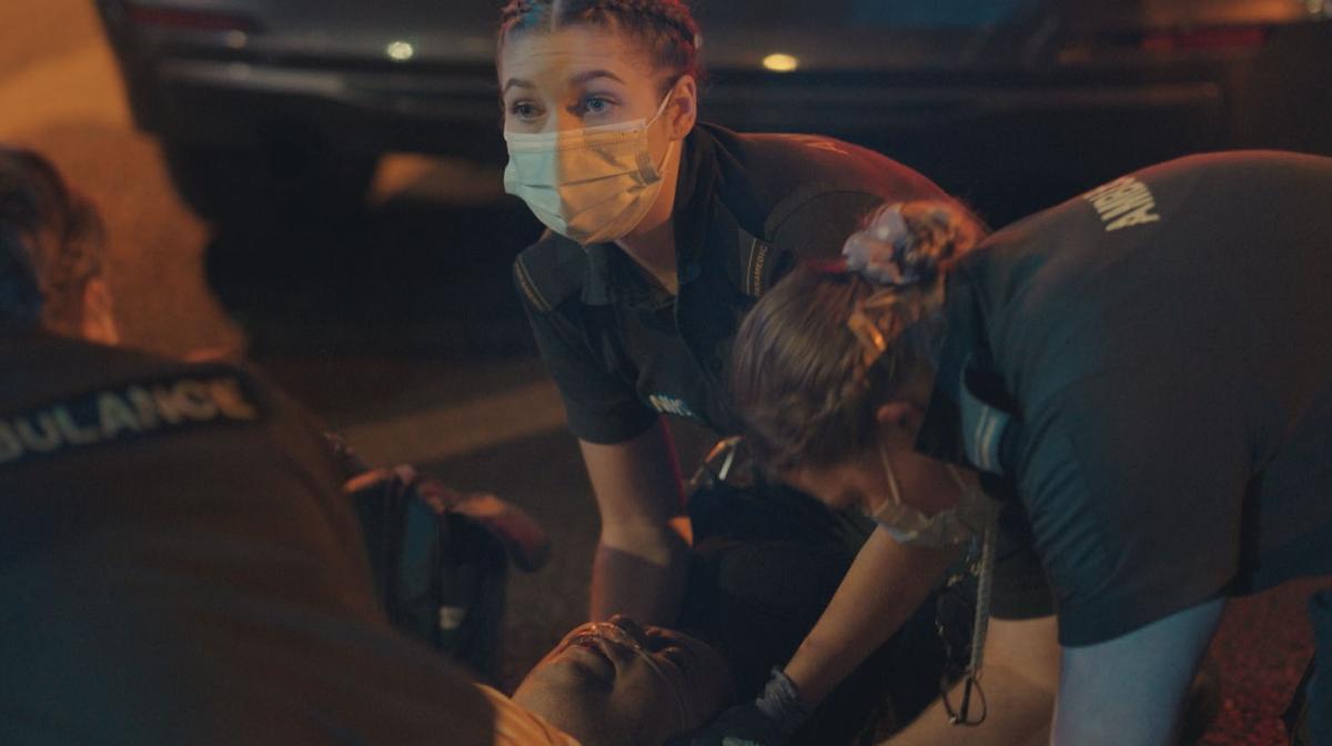 Still image from Emergency, showing responders treating an injured woman.