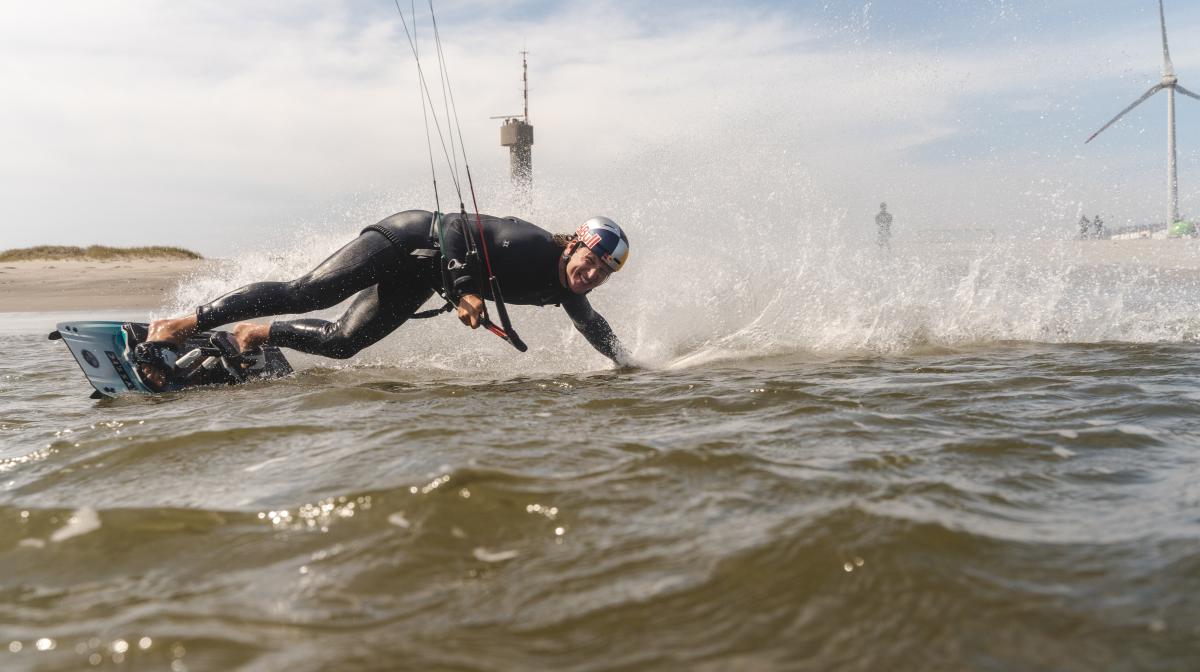 Cohan van Dijk smiling on the kiteboard in the sea.