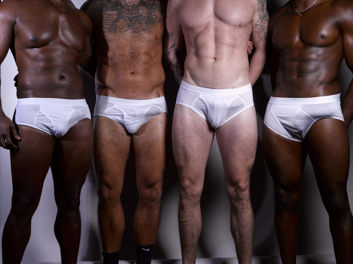 crotch level mid shot of four males in white briefs