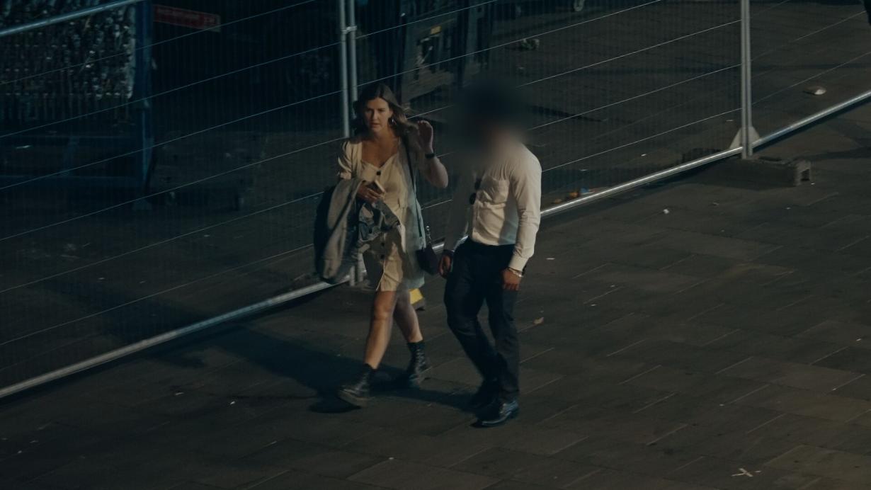 couple walking outside at night male's face blurred