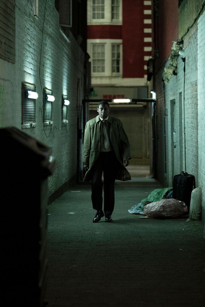Pierre walking in an alleyway at night
