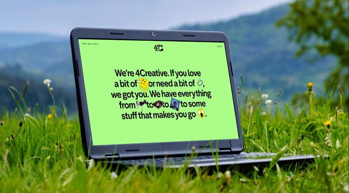 It shows a laptop in some grass. This is the website homepage. On a green background it says We're 4Creative. If you love a bit of (smiley face icon) or need a bit of (ring icon), we got you. We have everything from (cow icon) to (Claudia Winkleman icon) to some stuff that makes you (shocked face icon)